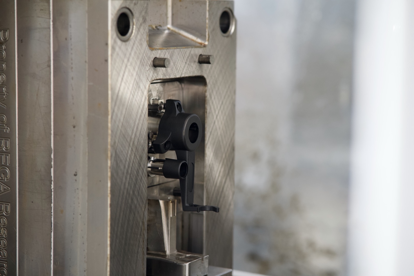 Bias housing mould tool open in the press with a moulded part inside